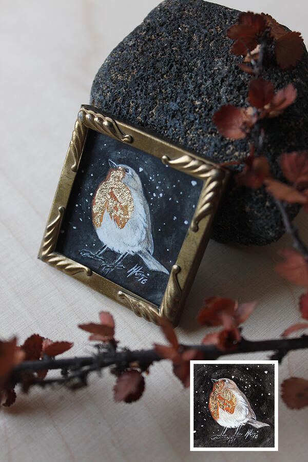 Traditionally painted artwork depicting a robin. Artwork has been framed in a vintage photo frames.