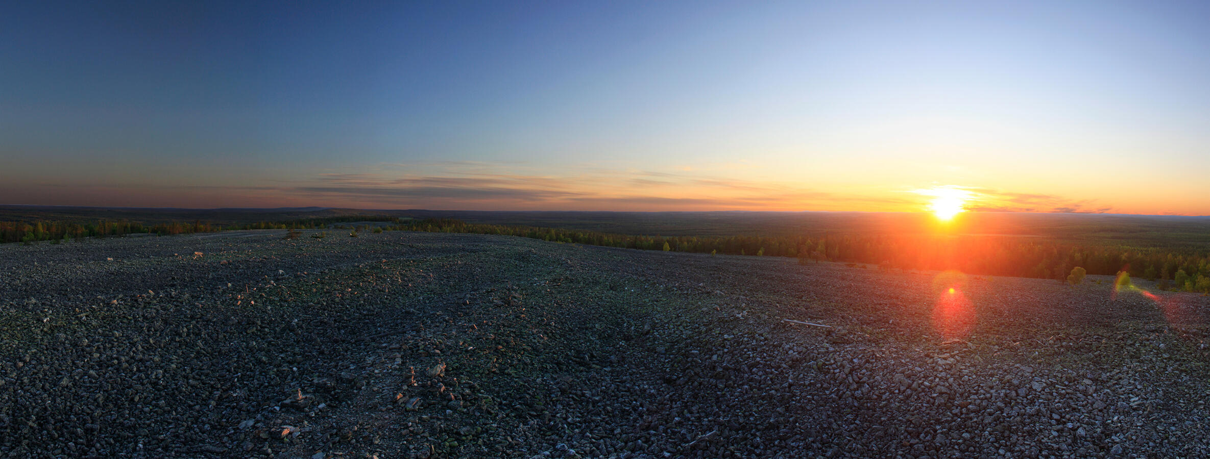 Photograph of a midnight sun at 00:00, taken on top of a rocky fell in Tervola, Finland.